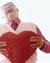 older man holding a heart