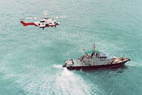 A Hong Kong harbor helicopter flies low over a police boat in China. Flying a helicopter over water is often much more dangerous than it looks; rough weather could make a shoot downright deadly. See more TV show pictures.