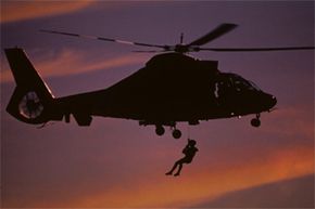 盘旋能力对于直升机参与的所有大胆行动都是至关重要的。图为一名勇敢的工人悬挂在美国海岸警卫队HH-65救援直升机上。＂border=