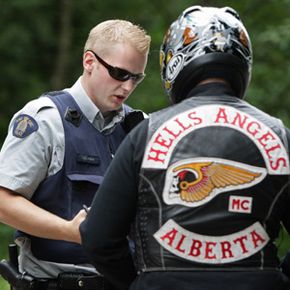 An RCMP officer stops an Alberta member of the Hells Angels motorcycle gang at a roadblock after he left the White Rock chapter's property in Langley, British Columbia, on July 26, 2008.