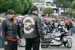 A pair of Hells Angels members look on as crowds jam a funeral home parking lot during the memorial for the Hells Angels San Francisco chapter leader in Daly City, Calif., on Sept. 15, 2008.