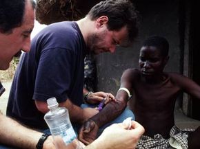 AIDS researcher Dr. Giuliano Rizzardini takes a blood sample from an AIDS patient with Karposi's sarcoma at a village outside Gulu, Uganda.