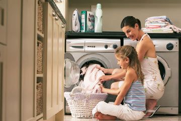 Girl helps mother with laundry.