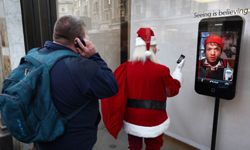 A man looks at a display of a Santa Claus figure with an iPhone at the Apple Store on Regents Street in London, England.