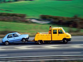 Recovery truck towing small automobile