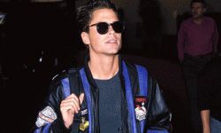 Rob Lowe wearing dark sunglasses and a bright '80s leather jacket