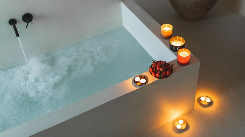 Romantic candle light in spa in modern interior. Protector skin treatment with aromatic candles and moisturiser foam. Beauty and spa concept. Anti-stress and detox procedure.