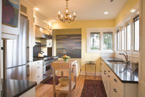 A modern kitchen with pale yellow walls and stainless steel appliances.