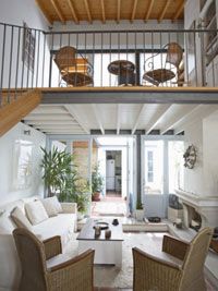 A white and airy living room and loft above.