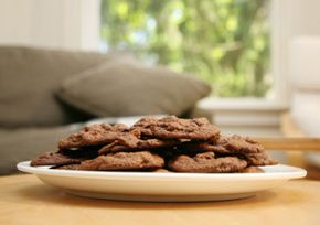 A plate of chocolate cookies site on a living room table.