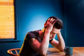 Man holding his head in pain after a night of drinking