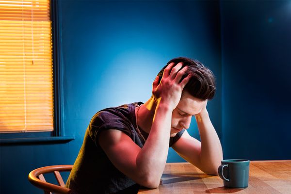 Man holding his head in pain after a night of drinking