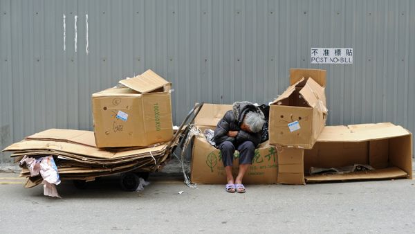 One man in poverty, outdoors with cardboard.