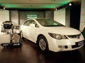 A Honda Civic Hybrid car and its displayed engine, left, are seen at an event in New Delhi, India, on June 18, 2008.