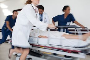 A team of medics push a gurney with a patient upon it.