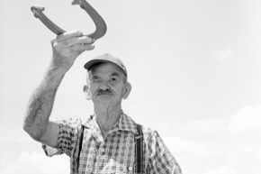 Mature gentleman focused on a horseshoe throw