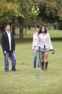 People playing horseshoes in a park