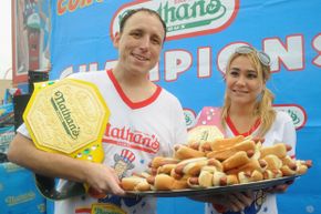 2014得主Joey Chestnut(男人的部门,61个热狗在10分钟内),杨爱瑾Sudo(女性的部门,34热狗在10分钟内)在国际的一年一度的“内森杯”国际吃热狗大赛在纽约。”border=