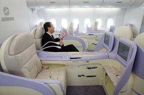 Man relaxing in first-class airplane seat. 