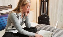 Woman in hotel bedroom on computer