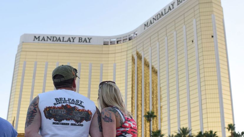 A couple stops on the Las Vegas Strip Oct. 4, 2017, to look up at the two broken windows in the Mandalay Bay hotel from which killer Stephen Paddock let loose the worst mass shooting in modern American history on Oct. 1, 2017. ROBYN BECK/AFP/Getty Images