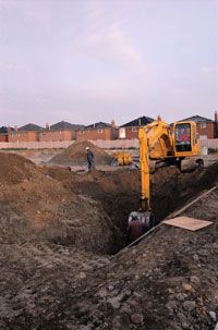 A backhoe excavates a basement.