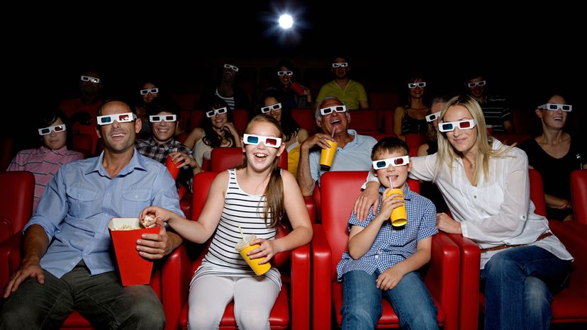 A family watching a movie in theater wearing 3d glasses