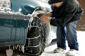 Carlos Santiago-Morales of Lakewood, Wash. checks his tire chains after driving from Lakewood to bring food, water and other supplies to his grandparents in Tacoma, Wash.