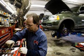 Al Van Sant, a mechanic at East Falls Gulf Service Station, gathers tools for brake work on an SUV in Philadelphia.