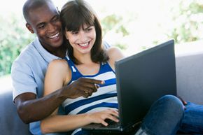 Couple holding laptop and laughing