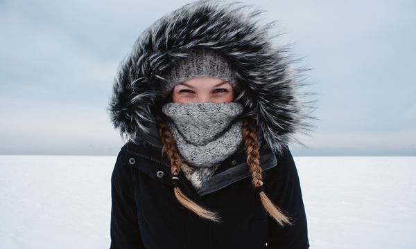 Person in warm clothing enjoying winter outdoors in snow.