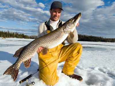 Fisherman proudly displays catch of fish outdoors.