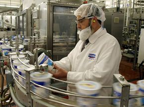 A rabbi inspects yogurt at a factory.