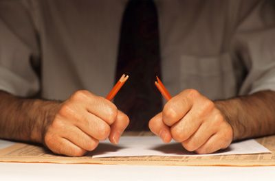 stressed man breaking pencil