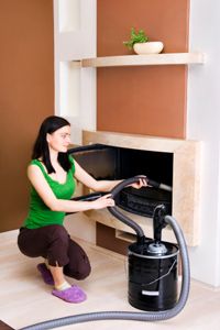 woman vacuuming ash from fireplace