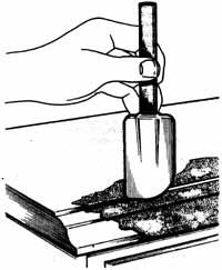 An illustration of a hand using a kitchen scraper on a surface.