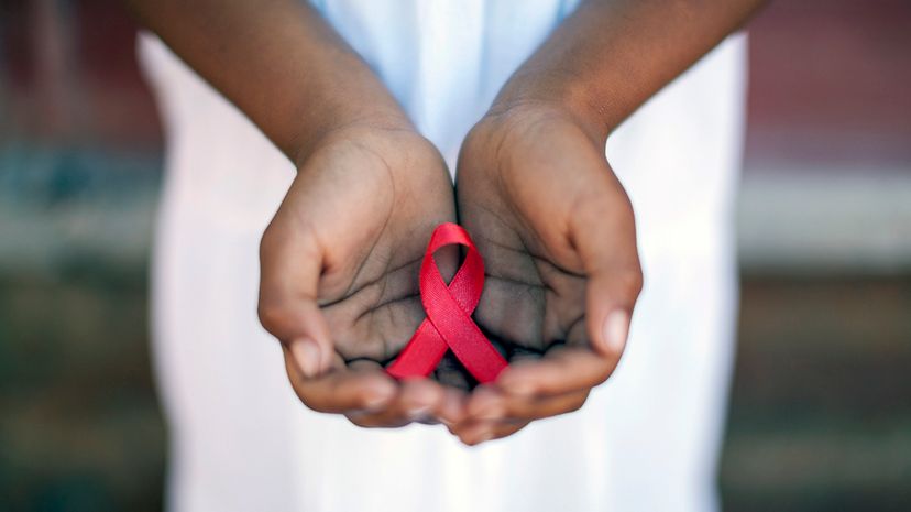 Child's hands holding an HIV awareness ribbon