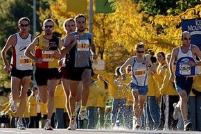 Runners grab water at an aid station during the 2004 Chicago Marathon as other participants run past.