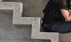 Woman sitting on concrete stairs.