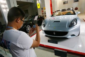 加州人拍照的法拉利在北京汽车展览会,中国,2009年。为期五天的展览展示了进口汽车,其中许多高价豪华车型18新利最新登入。”border=