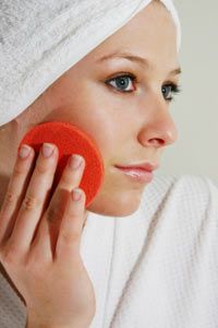 Woman with exfoliating pad to face.