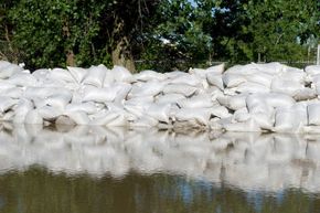 Sandbags holding back a mass of floodwaters. See more pictures of natural disasters.