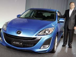 Takashi Yamanouchi, chief executive officer of Japan's Mazda Motor Corp., poses with the Mazda3 during a press conference in Tokyo, Japan. Some predict that a third of all new cars will use some kind of idle-stop system by 2012.