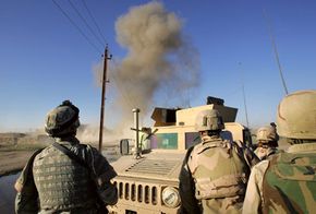 U.S. Army bomb team members watch the controlled detonation of an improvised explosive device (IED) to clear it from the streets in Baghdad, Iraq.