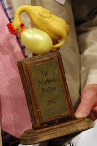 A proud (or at least tolerant) recipient brandishes a 2007 Ig Nobel Prize.