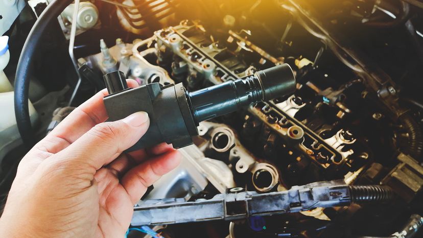 A hand holding an ignition coil.