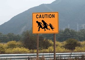 Signs like this one can be found near the U.S.-Mexico border, warning drivers to watch for illegal immigrants running across the highway.
