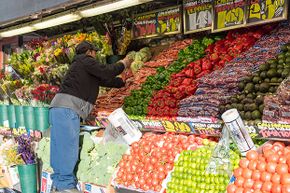 A Mexican immigrant arranges fruit in a convenience store in New York City. One study showed immigrants bettered the earnings of native-born Americans.
