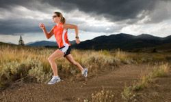 Athlete jogs outdoors in the sun.