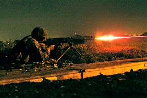 Cpl. Robert Giuliani, a Combat Logistics Company 36 Marine, fires tracer rounds from a 240G medium machine gun during the night fire portion of Exercise Dragon Fire 2009.